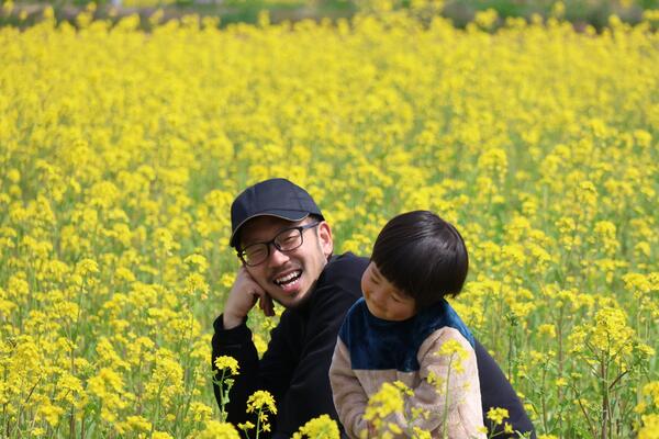 菜の花畑にいる親子の写真