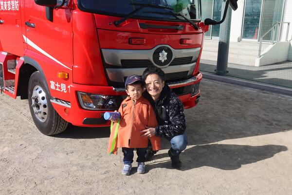 参加者が消防車と記念撮影する写真