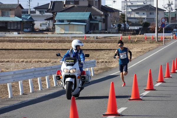 白バイに先導されている選手の写真