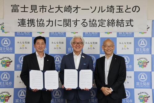 署名した協定書を持っている集合写真